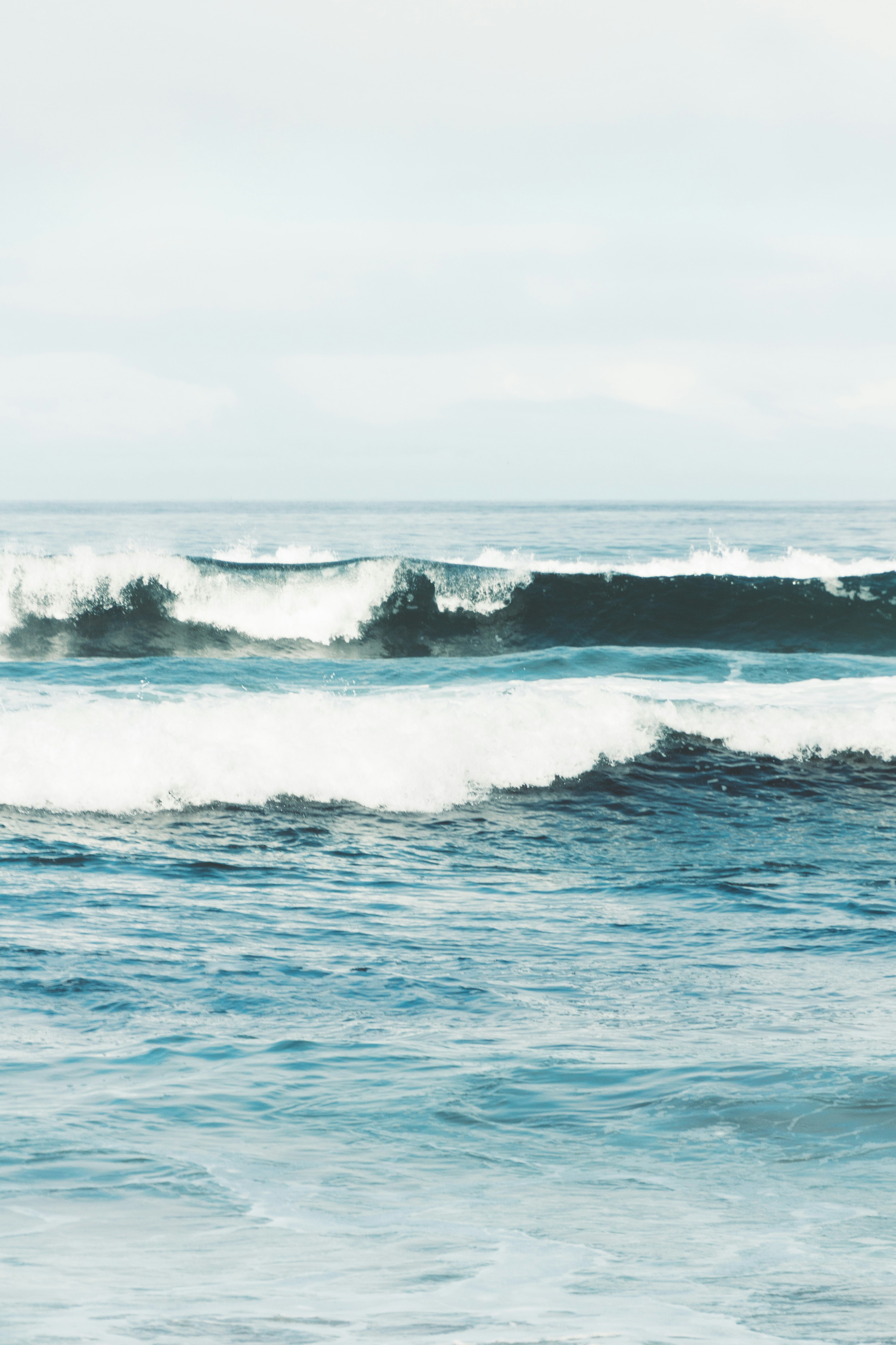 ocean waves under blue sky during daytime